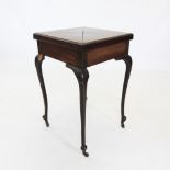An Edwardian mahogany envelope games table, the folding top enclosing a baize lined surface,