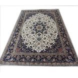 A modern Indian wool rug, with a central blue floral medallion on an ivory ground with trailing