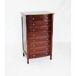 An Edwardian mahogany bow front chest of drawers, the shaped top with inlaid stringing, above