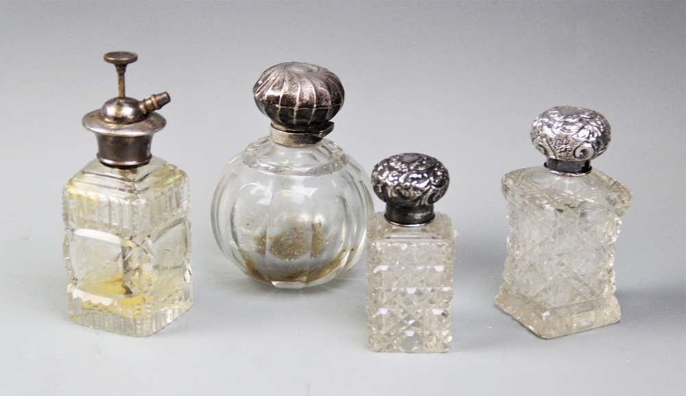 Three glass and silver topped dressing table jars, to include an Edwardian ovoid example by