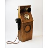 A vintage style dial operated telephone, probably homemade, the mouthpiece and dial set to an oak