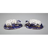 A pair of Victorian Staffordshire dalmatians, late 19th century, each modelled lying on a blue base,