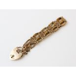 A 9ct gold gate link bracelet, 18cm long, suspending a 9ct gold heart-shaped padlock fastener,
