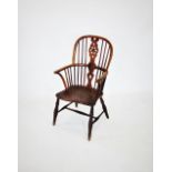 A late 18th/ early 19th century elm and ash wheel back windsor elbow chair, the hoop back centred