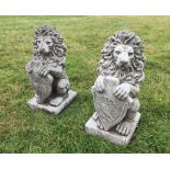 A pair of reconstituted stone heraldic lions, each modelled raised with their forelegs supporting