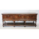 An early to mid 18th century Montgomeryshire oak dresser, the rectangular moulded two plank top