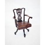 A Chippendale style mahogany revolving desk chair, late 19th century, with a carved and interlaced