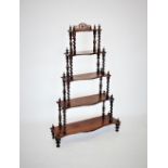 A Victorian rosewood what not, with five graduated serpentine tiers, the upper tier with an openwork