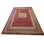 A Sarook Kashan silk rug, of neo-classical design against a burgundy ground, 290cm x 220cm
