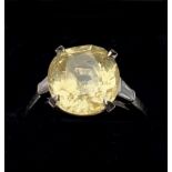 A yellow sapphire and diamond ring, the central cushion mixed cut sapphire claw set with a