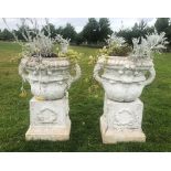 A near pair of white painted, two handled urns, each with tulip moulded base section, below a