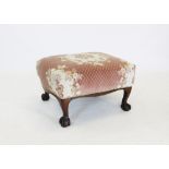 An early 20th century mahogany foot stool, the later recovered and upholstered seat raised upon