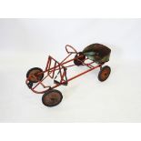 A mid 20th century child's pedal go kart, possibly Tri-ang, the tubular frame raised upon solid