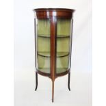 An Edwardian mahogany demi-lune display cabinet, the frieze with trailing inlay above the single bow