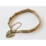 A 9ct gold bracelet, the yellow gold gate-link chain stamped '9' and '.375', 17cm long, suspending a