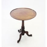 A 19th century mahogany tripod lamp table, the circular tray top raised upon a fluted tapering