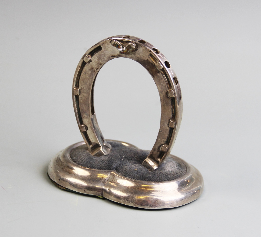 A silver novelty hat pin and watch stand by Sampson Mordan & Co, designed as a horse shoe in upright