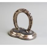 A silver novelty hat pin and watch stand by Sampson Mordan & Co, designed as a horse shoe in upright