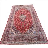 An Iranian Tabriz rug, wool/cotton, with a central foliate blue medallion on a red ground, 290cm x