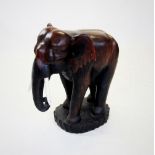 A carved hardwood model of an elephant, 20th century, modelled in a standing position and applied