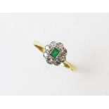 An early 20th century emerald and diamond ring, comprising a central rectangular step cut emerald