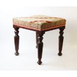 A mid-19th century mahogany foot stool, the square needlepoint top supported by four tapered