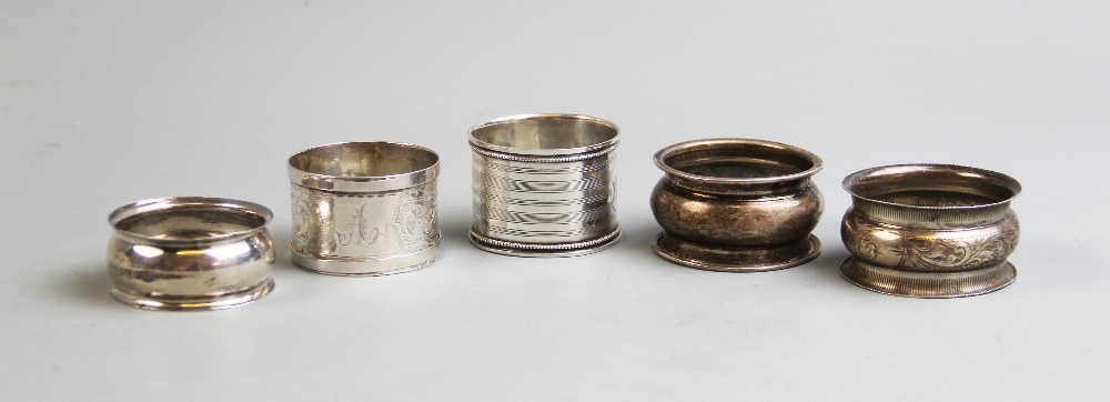 An Edwardian silver napkin ring, Brockington Brothers, Chester 1902, together with four further