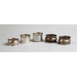 An Edwardian silver napkin ring, Brockington Brothers, Chester 1902, together with four further