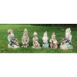Six painted concrete garden gnomes, to include a pair of gnomes with wheelbarrows 35cm H, and four