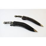 Two Nepalese Kukri knives and sheaths, each with horn handle set with white metal lion mask mount