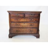 A mid 18th century oak and mahogany cross banded chest of drawers, with two short over three long