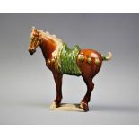 A Chinese Sancai glazed pottery model of a horse, late 19th/early 20th century, in the Tang