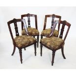 A set of four late Victorian walnut dining chairs, each with a concave rail back above a stuff