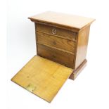 An early 20th century honey oak fall front specimen cabinet, with a moulded cornice