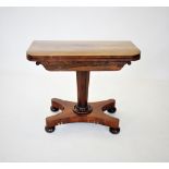 A William IV rosewood games table, the rectangular folding top with rounded corners enclosing a