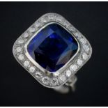 A sapphire and diamond ring, the central cushion mixed cut sapphire with a border surround of