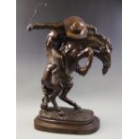 After Frederic Remington (1861-1909), a bronze sculpture modelled as a cowboy on a rearing horse,