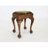 A late 19th/early 20th century oak stool, the rectangular padded tapestry seat raised on cabriole