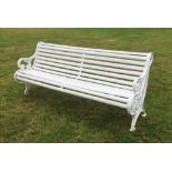 A large white painted garden bench with cast iron supports, the wooden slatted seat terminating with