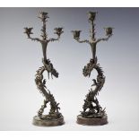 A pair of Japanese bronze figural candelabra, 20th century, each modelled as dragons supporting a