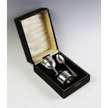 A silver christening set, comprising a weighted egg cup and spoon by S Blanckensee & Son Ltd,