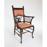 An Edwardian mahogany elbow chair, the carved top rail above a shaped padded back rest and a fan
