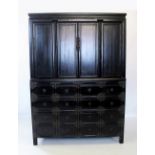 A large Chinese black lacquered cabinet, early 20th century, the upper section with four cupboard