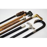 Seven assorted walking canes, to include, an ebonised example with a continental silver handle