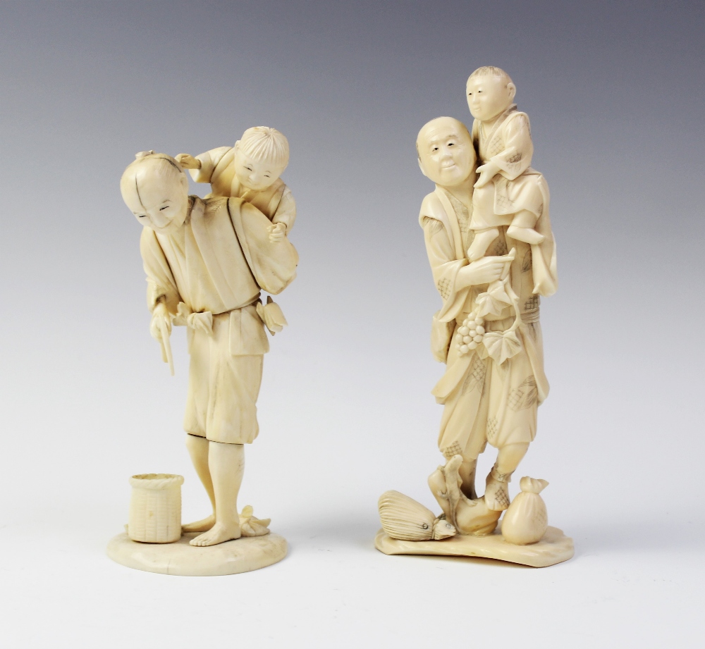 A Japanese carved ivory okimono, Meiji period (1868 - 1912), modelled as a father and child standing