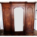 A Victorian burr walnut breakfront triple wardrobe, the stepped cavetto cornice above a central