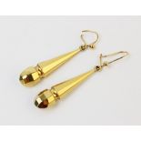 A pair of yellow metal drop earrings, of tapering faceted baton form, length of each drop 34mm, with