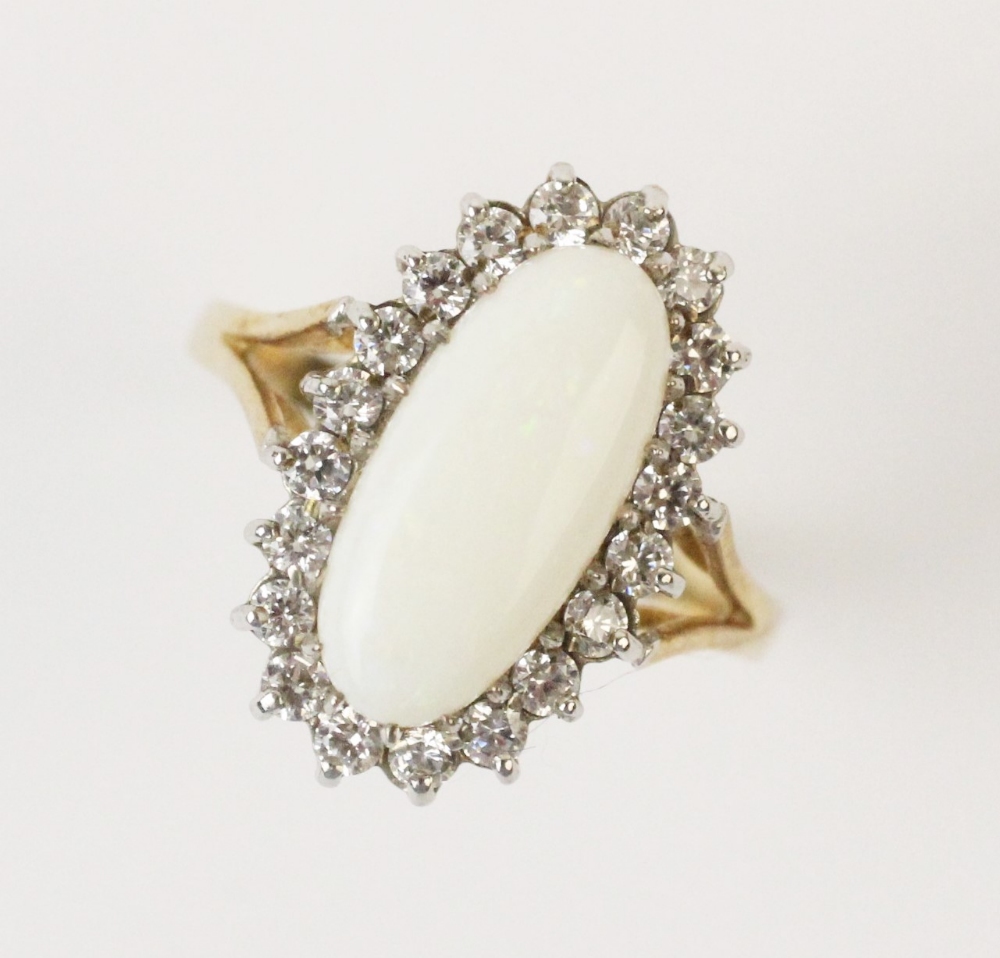 An opal cluster ring, comprising a central oval white opal cabochon measuring 15mm x 7mm, with a