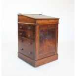 A Victorian mahogany davenport, the hinged and sliding writing slope enclosing two small drawers,