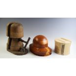 A collection of milliner's hat blocks and stands of various sizes and designs, mostly wooden, some